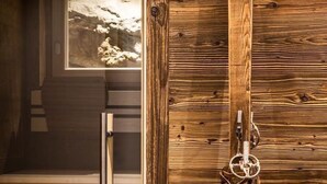 Un muro di legno con uno sci appoggiato, un secchio di metallo e un quadro incorniciato sullo sfondo.