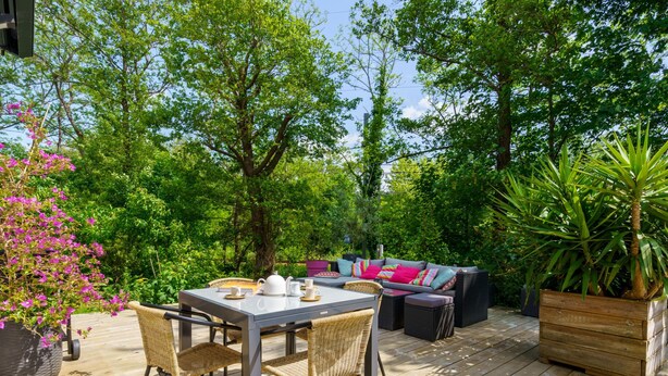 An outdoor patio with a table and chairs, a sofa, and a potted plant. - Chemin du Ruisseau d'Arcangues by Interhome (Anglet)