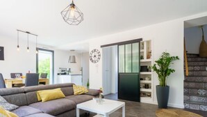 A modern living room with a sectional sofa, a white coffee table, and a dining area with a table and chairs. - Chemin du Ruisseau d'Arcangues by Interhome (Anglet)