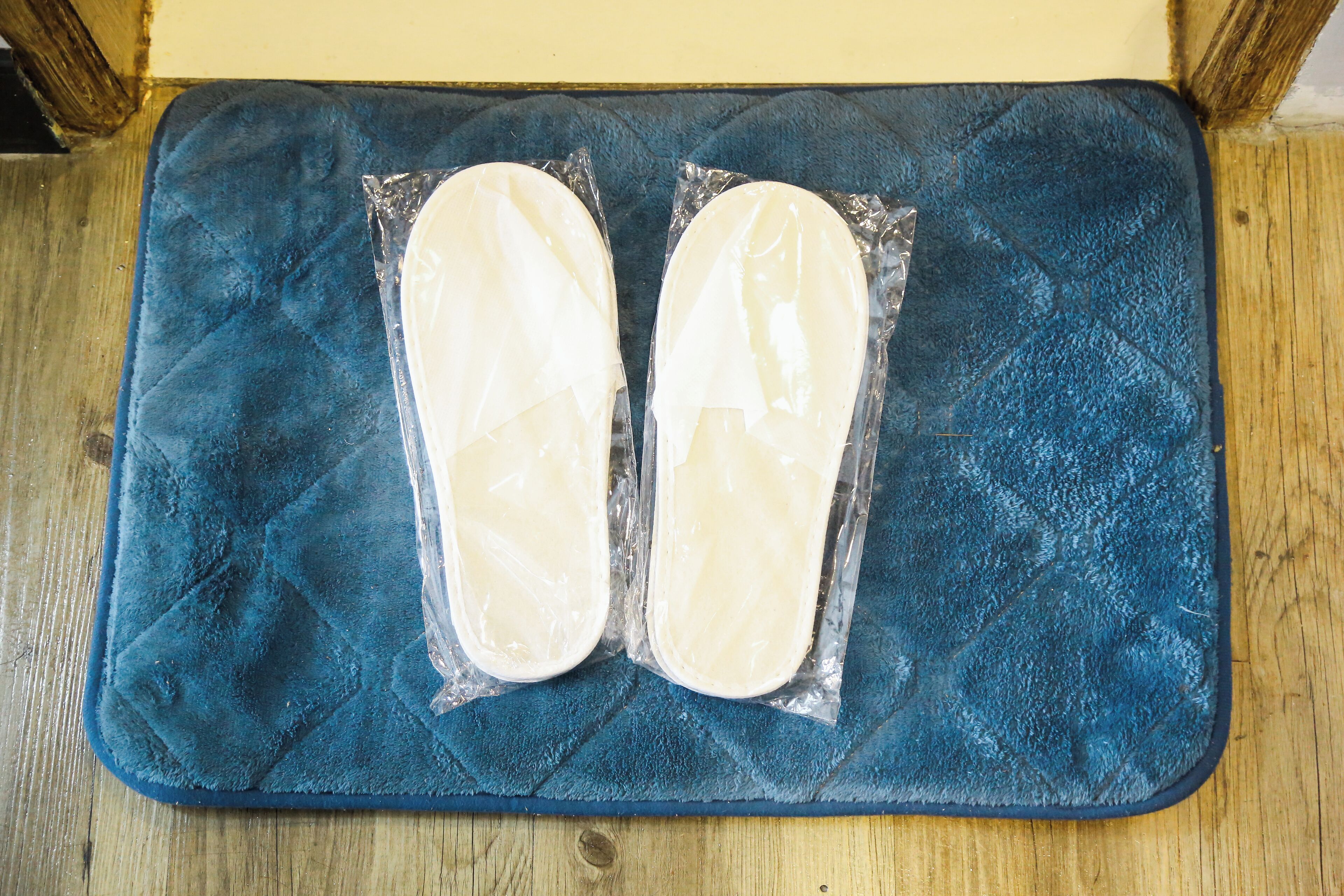 A blue textured mat with two white objects wrapped in plastic on it.
