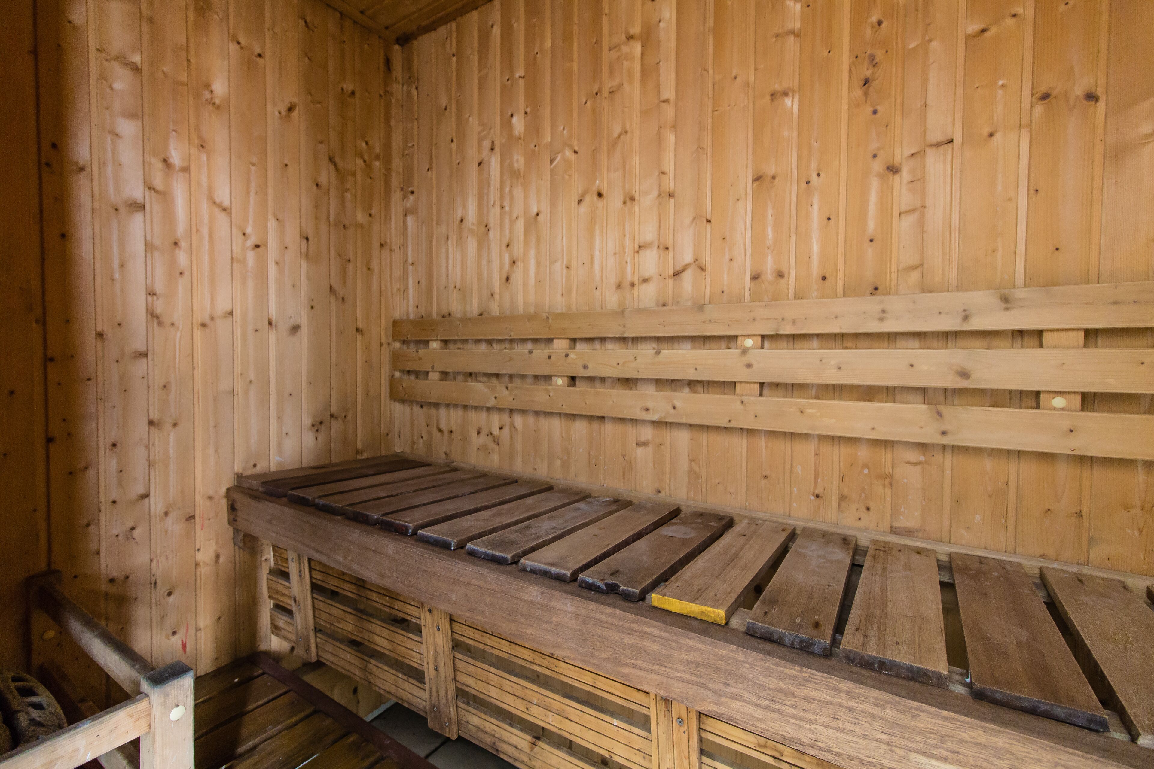 A wooden sauna with benches and a bench seat.