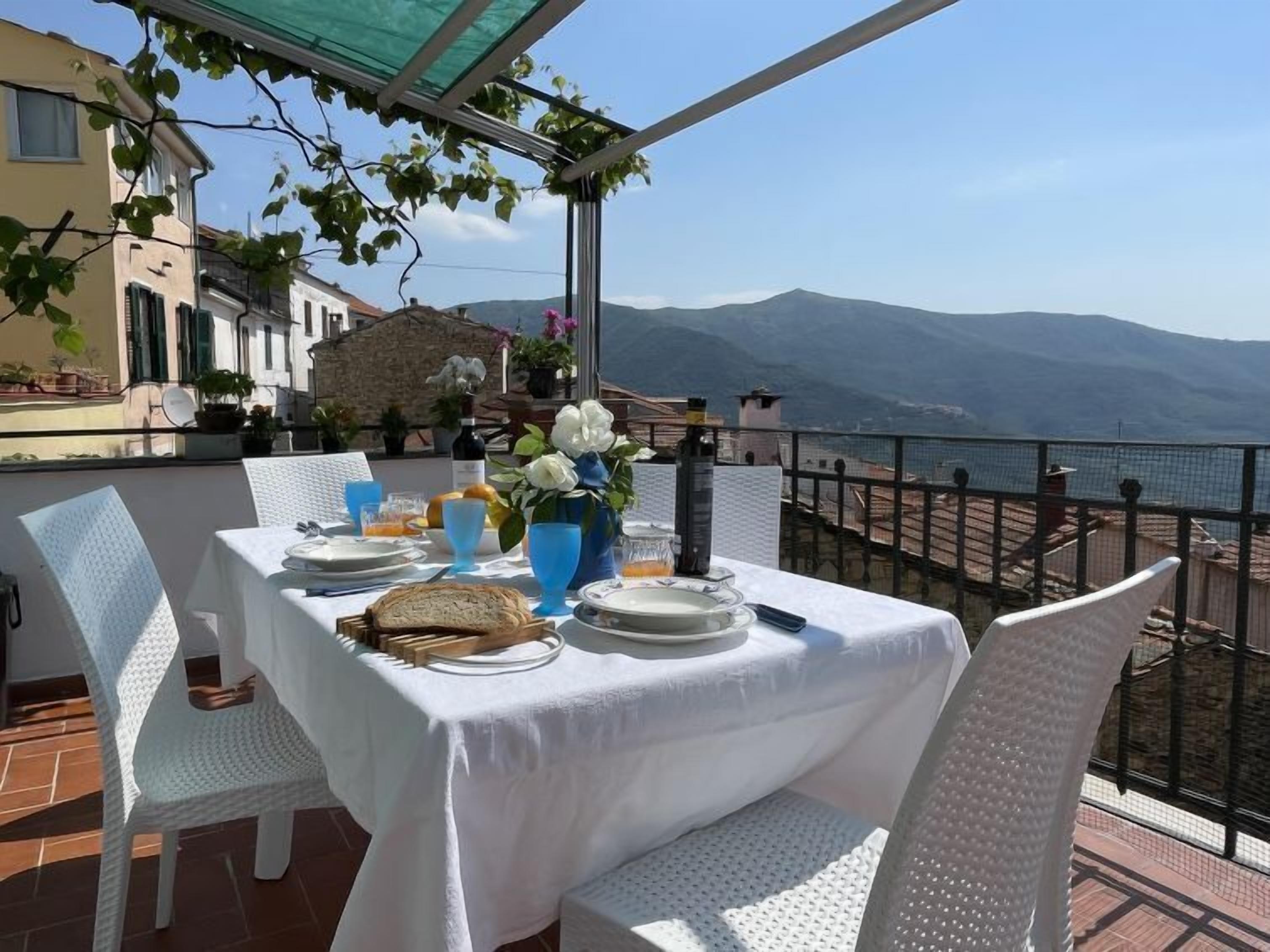A table set for two with a view of mountains and a body of water.