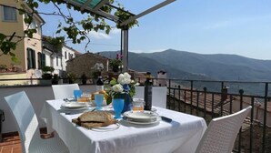 A table set for two with a view of mountains and a body of water. - Casa Sylvie by Interhome (Lucinasco)