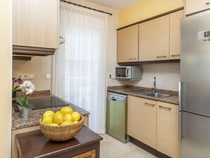 Een koelkast, een microgolfoven, een oven, kookgerei, borden en bestek