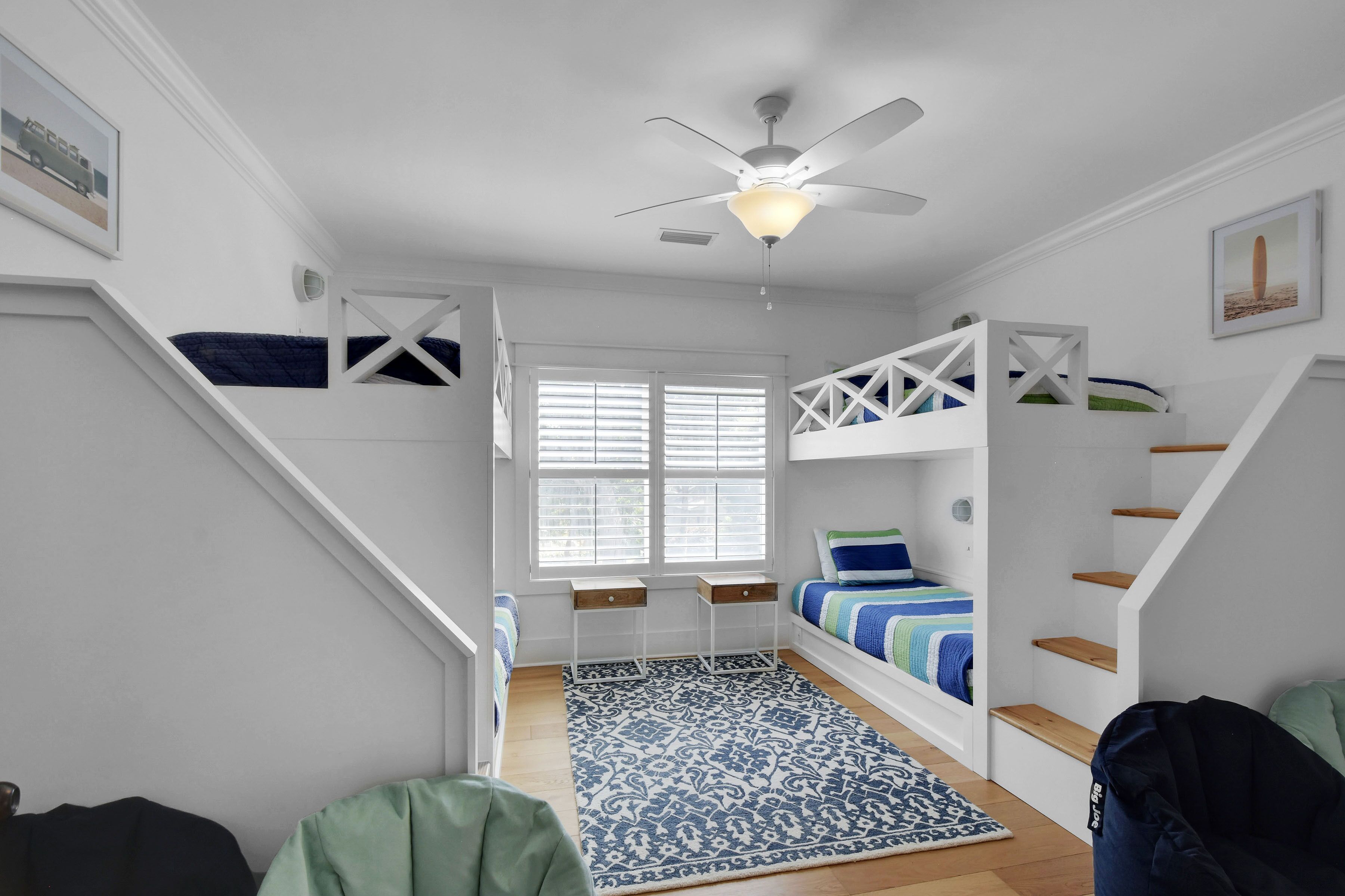 Ein Zimmer mit Etagenbetten, einem Deckenventilator und einem Fenster mit Jalousien.