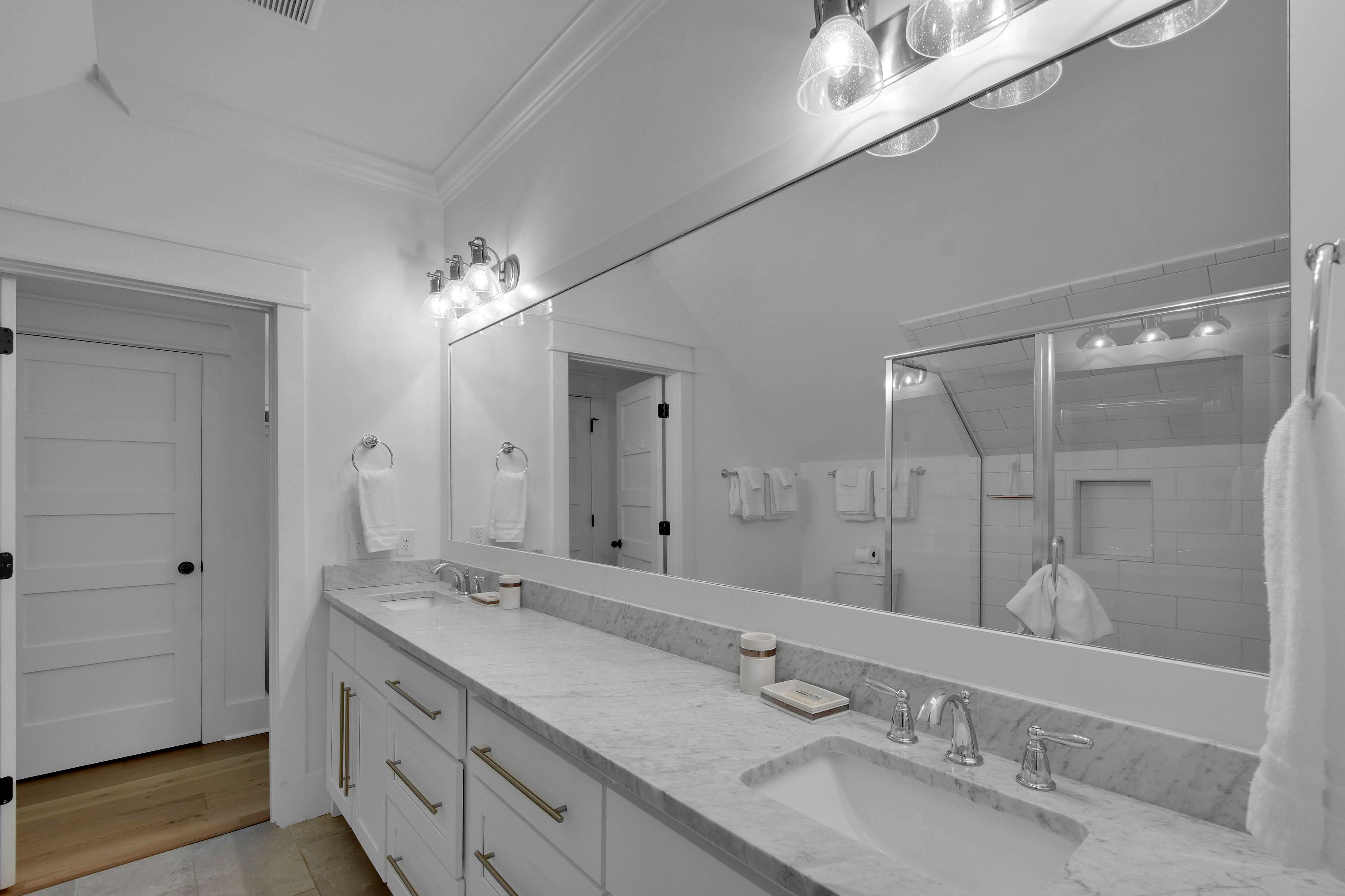 Un baño moderno con un espejo grande, dos lavamanos y un mueble de tocador con cajones.