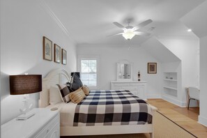 A bedroom with a bed, nightstand, dresser, and a ceiling fan. - Large Heated Pool • Walk to Restaurants • 2 King Ensuites • EV Charger (St Simons)