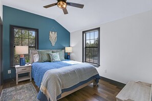 A bedroom with a large bed, two bedside tables with lamps, a ceiling fan, and two windows. - Terlingua at the Bend I Wimberley, seclusion, views (Wimberley)