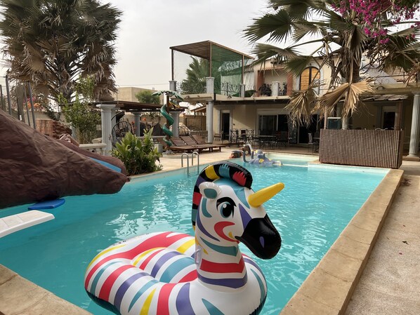A swimming pool with a colorful inflatable unicorn float.