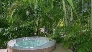 Een hottub omringd door weelderige tropische beplanting.