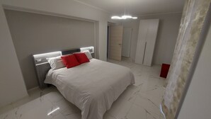 A modern bedroom with a bed, a nightstand, a wardrobe, and a bathroom visible in the background. - 4 Bedroom Private vacation home in Govone (Govone)