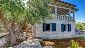 A stone house with a balcony, a tree in front, and a stone pathway. - And001 in Andrano With 4 Bedrooms and 2 Bathrooms (Andrano)