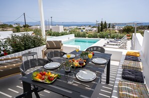 A rooftop dining area with a pool, outdoor seating, and a view of the landscape. - Ultimate Luxury Paradise Villa In Paros (Paros)