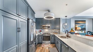 A modern kitchen with grey cabinets, stainless steel appliances, and a central island.