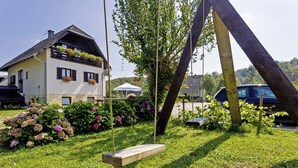 Una casa con giardino, un'altalena e un'auto parcheggiata.