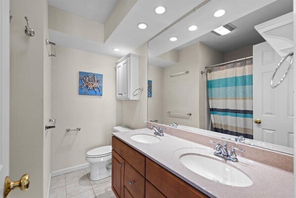 Un baño moderno con dos lavamanos, inodoro y ducha.