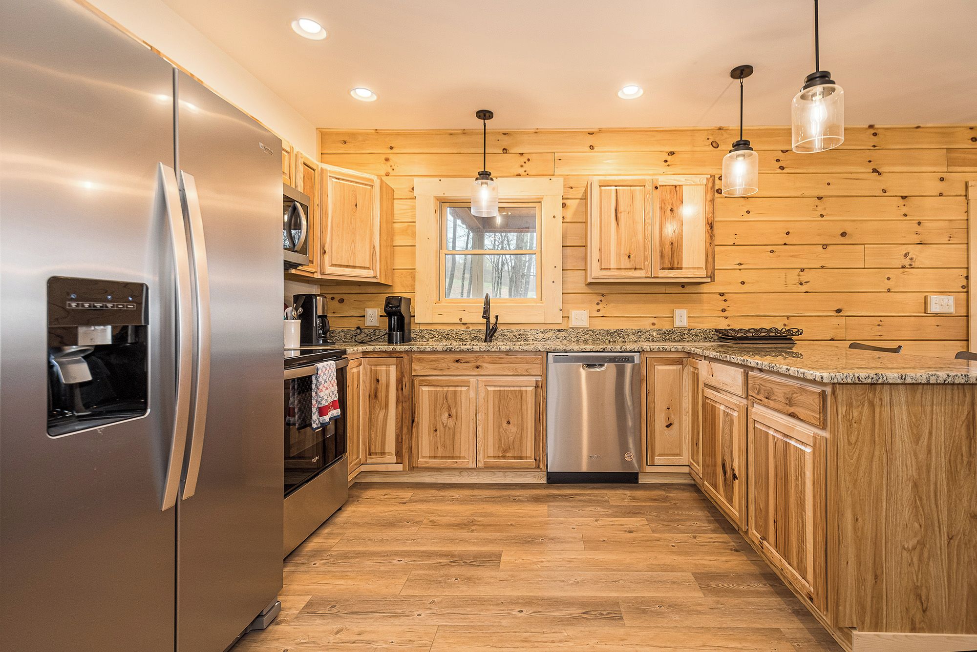 A kitchen with wooden cabinets, stainless steel appliances, and a granite countertop.