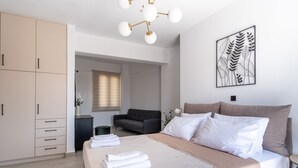 Un dormitorio moderno con una cama grande, un armario, un sofá y una obra de arte colgada en la pared.
