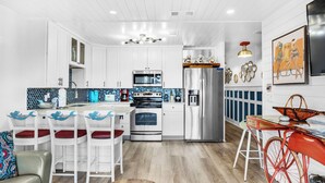 Una cocina moderna con armarios blancos, una isla central y una bicicleta roja.
