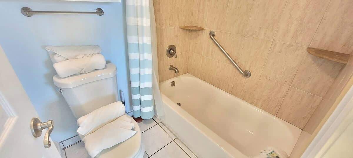 Une salle de bain comprenant des toilettes, une baignoire et un espace douche.
