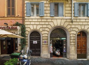 Un edificio con puertas arqueadas, números 215 y 216, una tienda llamada 