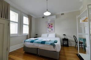 A bedroom with a bed, bedside tables, a chair, a desk, and a wardrobe. - Hope St Cottage I • Restored Stay • Bathurst CBD (Bathurst)