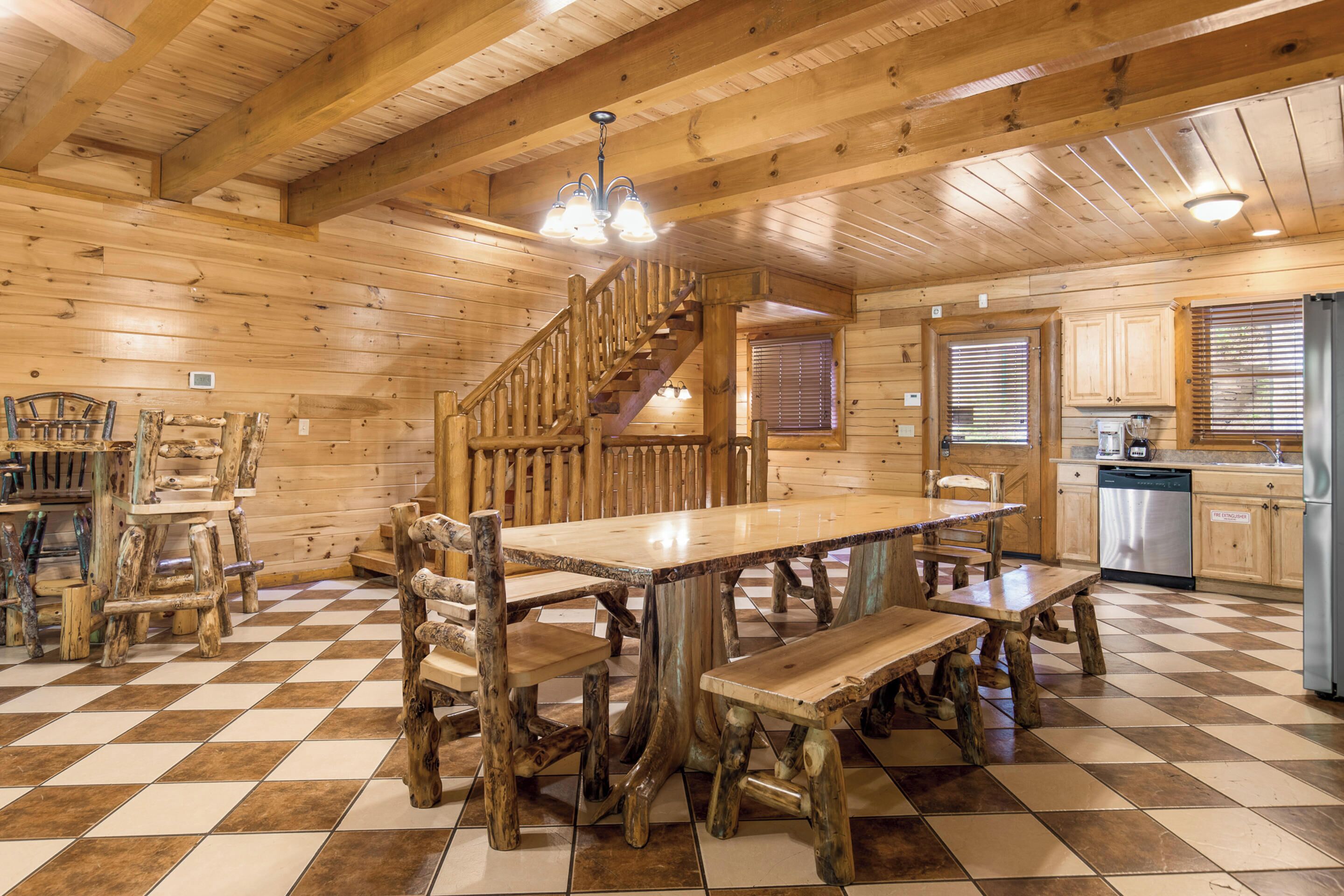 A wooden interior with a checkered floor, a central dining table, and rustic chairs.