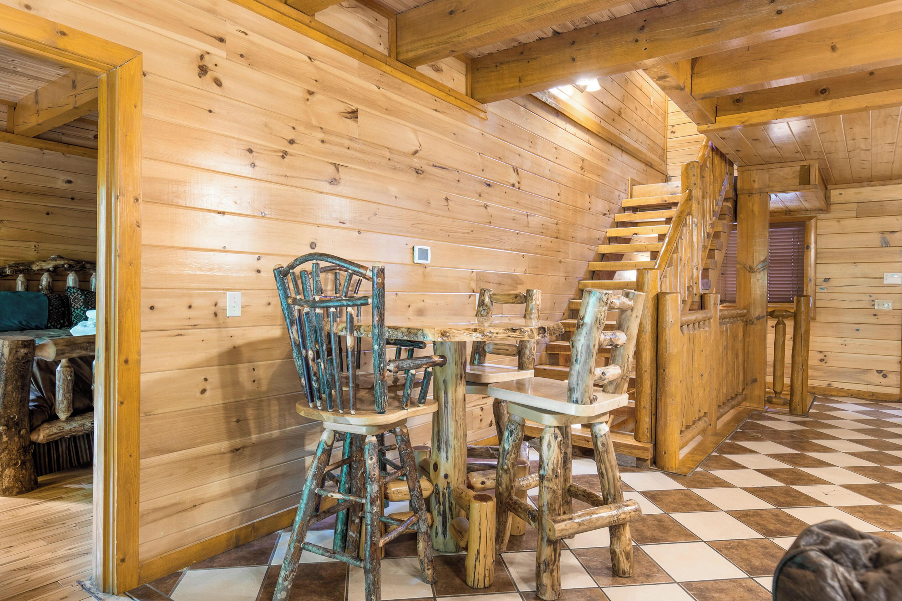 A rustic wooden interior with a checkered floor, wooden walls, and a staircase.