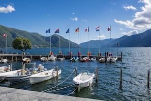 Un port de plaisance avec des bateaux amarrés, un quai et des montagnes en arrière-plan.