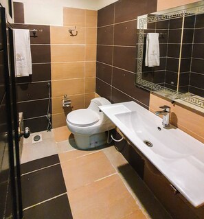 A bathroom with a toilet, sink, and mirror.