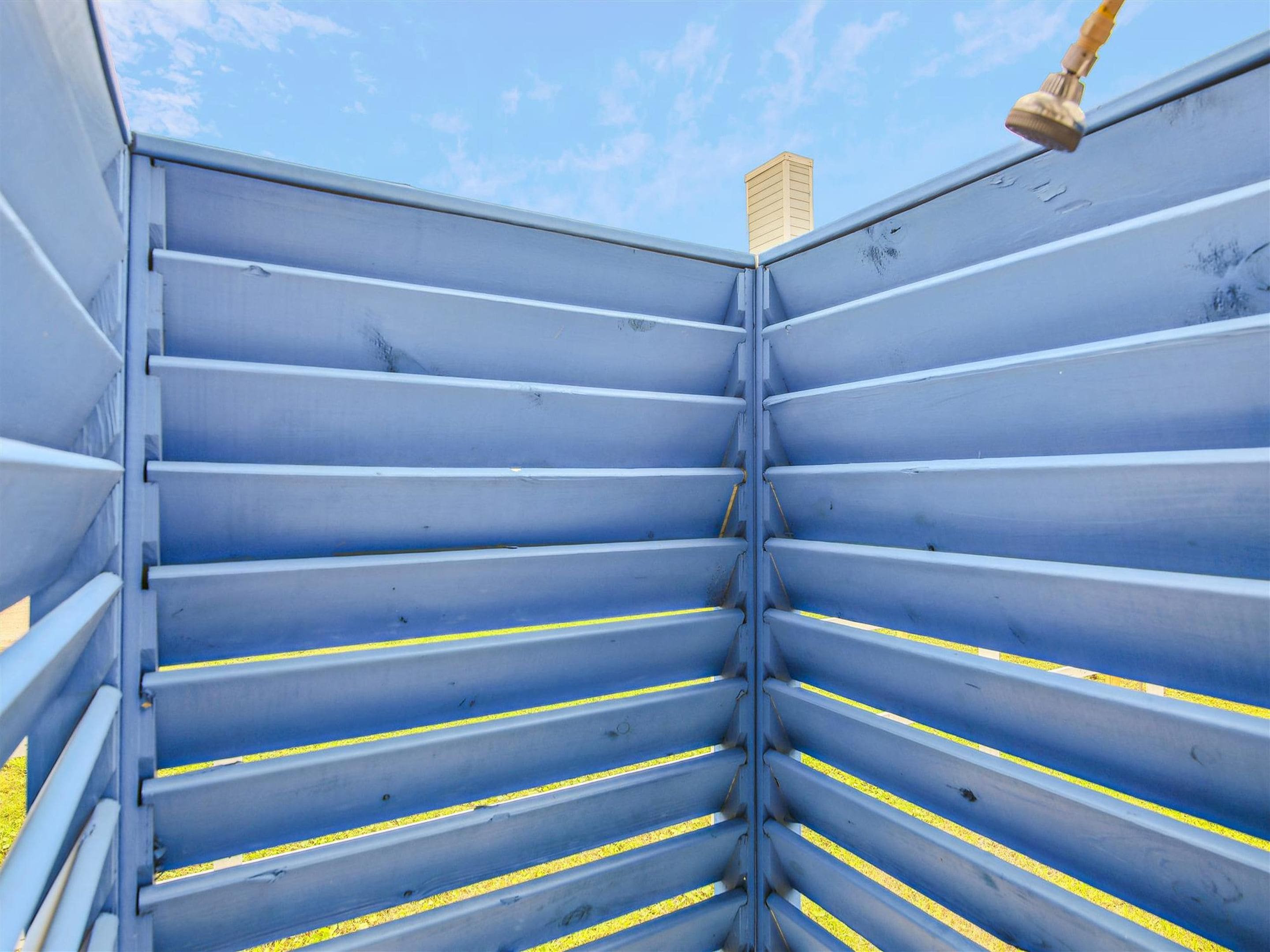 A blue metal structure with horizontal slats and yellow lines, possibly a part of a building or equipment.