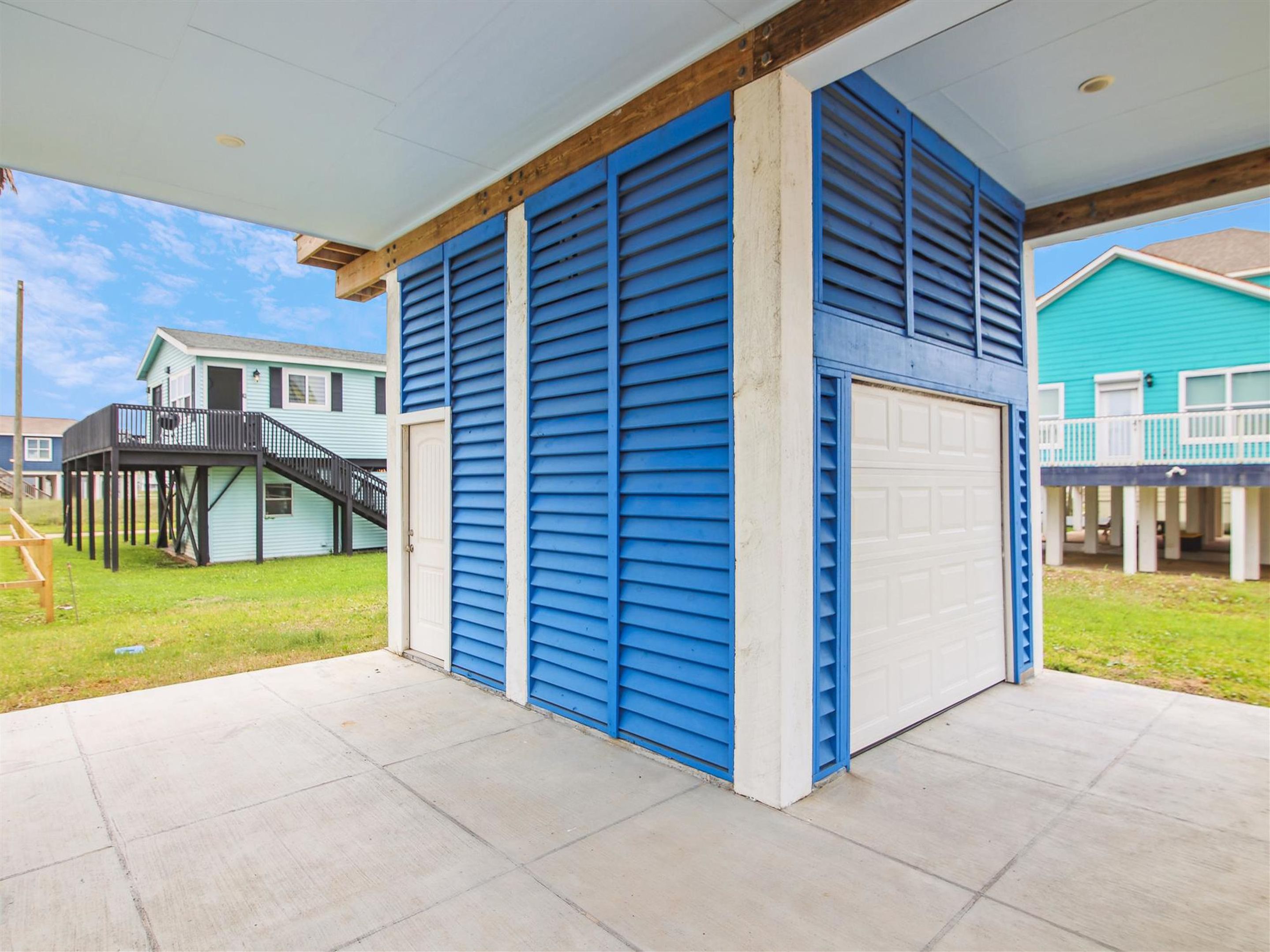 A two-story building with a blue exterior and a white garage door.
