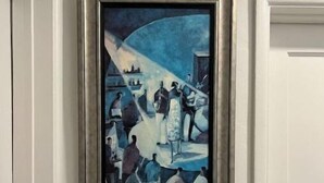 A framed painting of a blue-toned abstract scene with figures and objects, hung on a white wall. - Home on Yucca (El Centro)