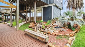 A residential property with a covered patio, a stone garden, and a palm tree. - Blue Fin by Ryson Vacation Rentals (Freeport)