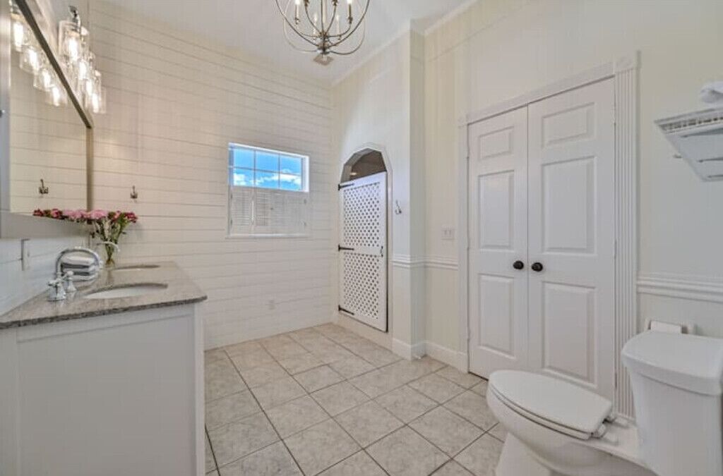 Une salle de bain avec un meuble-lavabo blanc, des toilettes et un espace douche.
