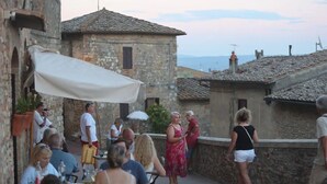 An outdoor café with stone buildings and tables. - Welcome "Casa San Gimi" your perfect base for exploring the wonders of Tuscany!  (San Gimignano)