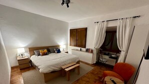 A bedroom with a bed, bedside table, lamp, and a small wooden bench. - Welcome "Casa San Gimi" your perfect base for exploring the wonders of Tuscany!  (San Gimignano)
