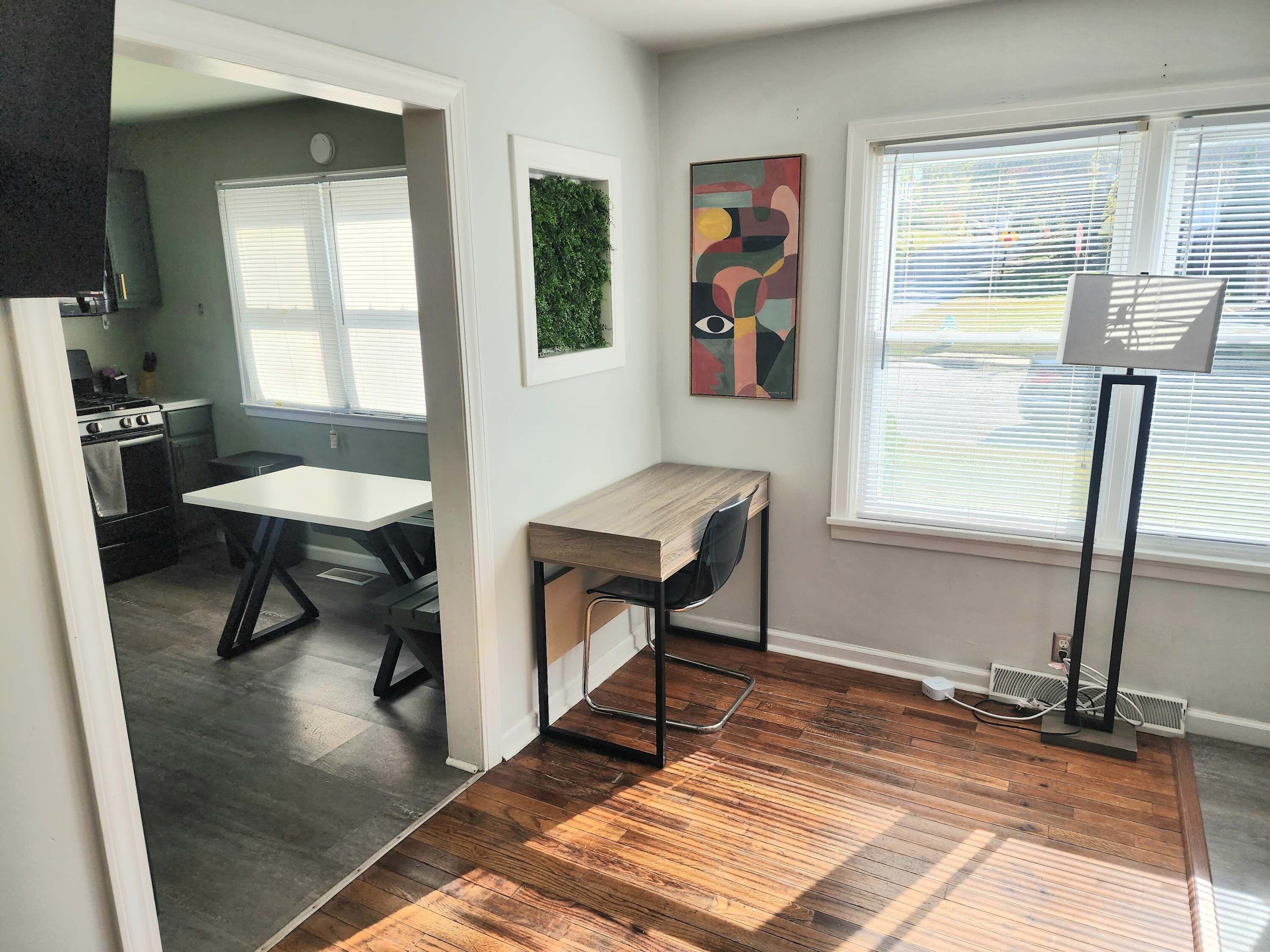 A modern kitchen with a built-in oven and a dining area with a wooden table and chairs.
