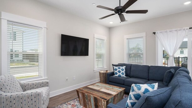 A living room with a sofa, a chair, a coffee table, and a ceiling fan. - The Lighthouse -Steps to Beach!  Luxury Amenities! (Corolla)
