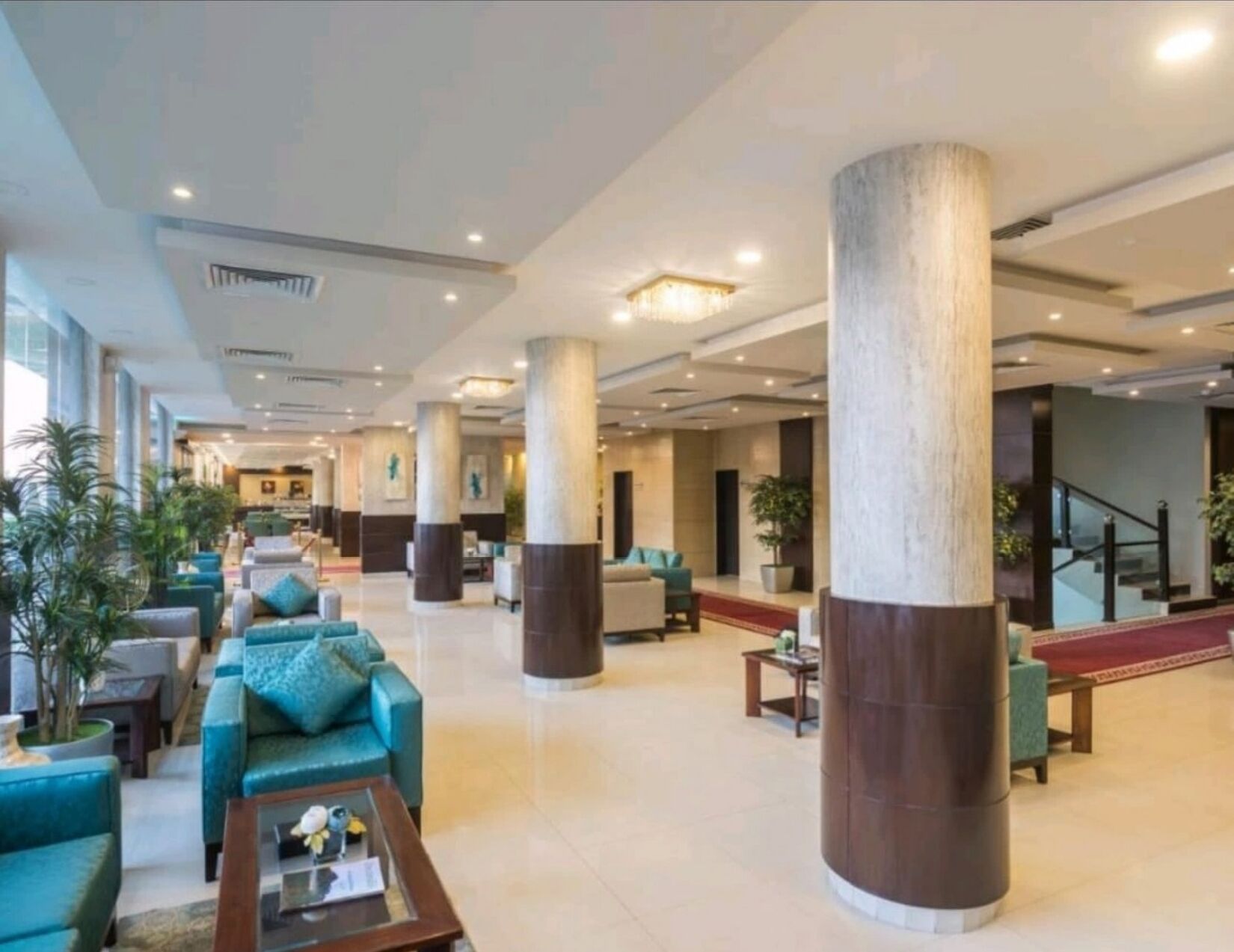 A spacious lobby with high ceilings, large columns, and seating areas.