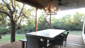 Une terrasse extérieure avec une plateforme en bois, une table et des chaises.