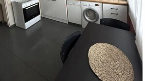 A compact kitchen with a stove, microwave, and washing machine. - Appartement Cosy (Clermont-Ferrand)