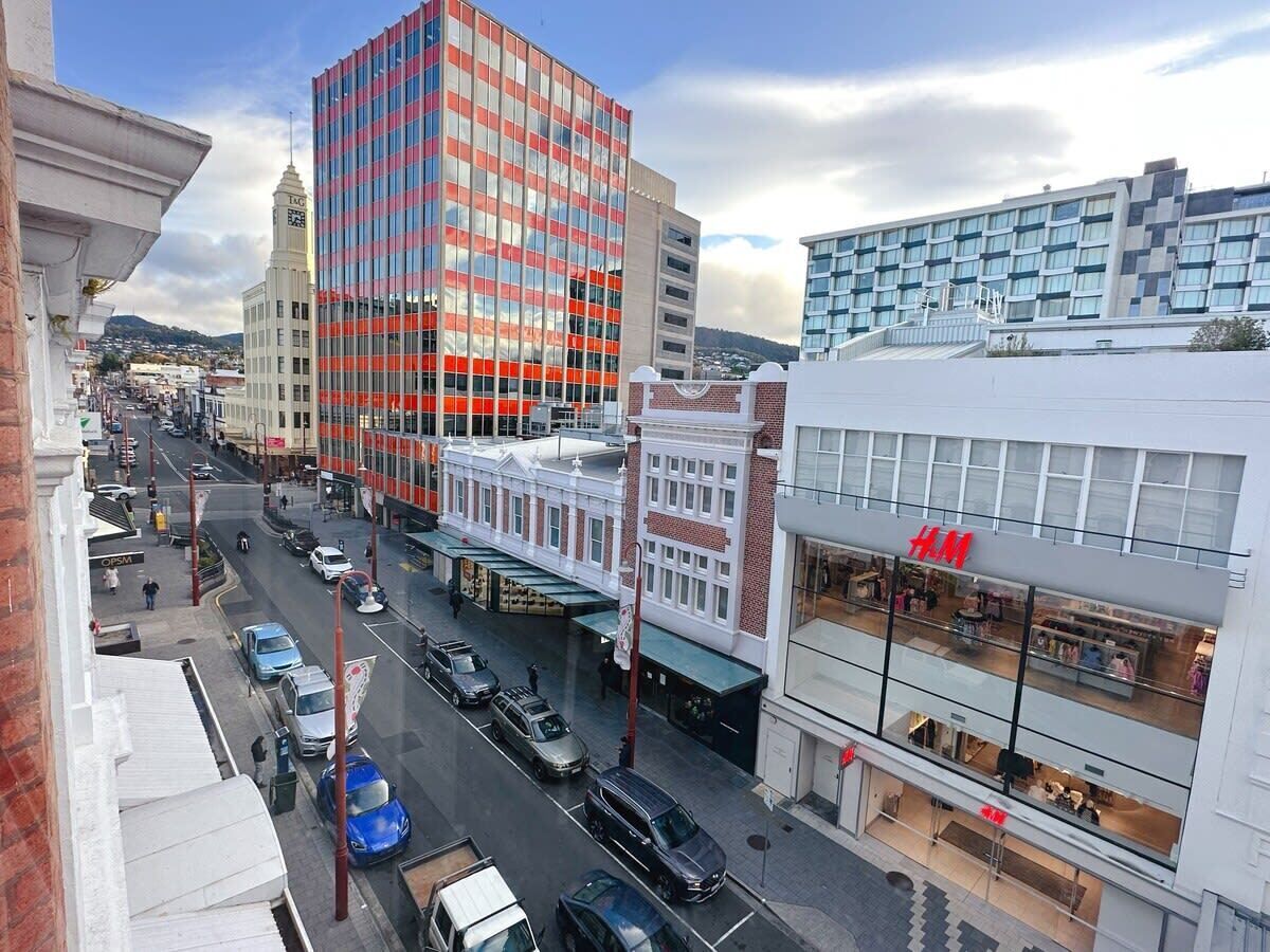 Une rue de la ville bordée d’immeubles modernes, dont un magasin H&M.