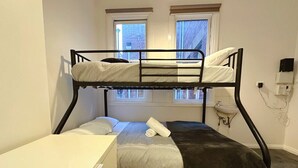 A bunk bed room with a desk, two windows, a sink, and a wall-mounted phone. - Central Collins Residence at Inner City (Hobart)