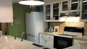 A kitchen with white cabinets, a stainless steel refrigerator, a black stove, and a pendant light. - Island Breeze Walk to Beach 3/2 Sleeps 10 Okaloosa Island Fort Walton Beach (Fort Walton Beach)