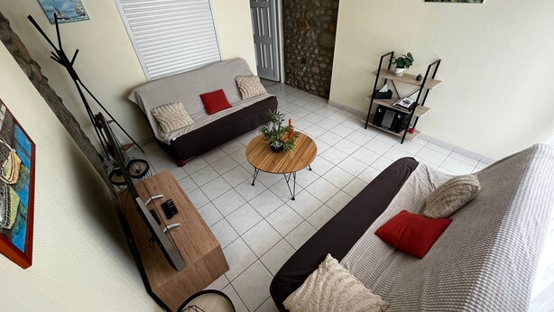 A modern living room with a sofa, coffee table, and a dining area. - Une Maison à la Mer - Proche de la marina (Saint-Cyprien)