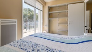 A bedroom with a bed, a window with blinds, a radiator, and a closet with shelves. - L'Hollywood Zen - One Bedroom Apartment, Sleeps 4 (Saint-Jean-de-Monts)