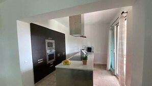 Une cuisine moderne dotée d’un îlot central, d’un four encastré et d’un four à micro-ondes.