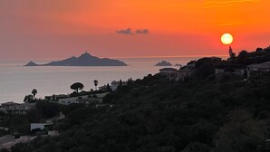 A sunset over a coastal town with visible buildings and hills. - Apartment with panoramic view of the Sanguinary Islands (Ajaccio)