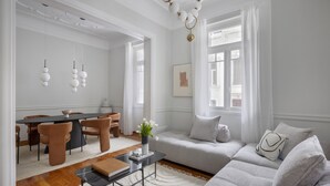A modern living room with a grey sofa, a dining table with chairs, and a coffee table. - Beautiful Acropolis Villa 3BR 9ppl 10 minutes Metro&Museum (Athina)